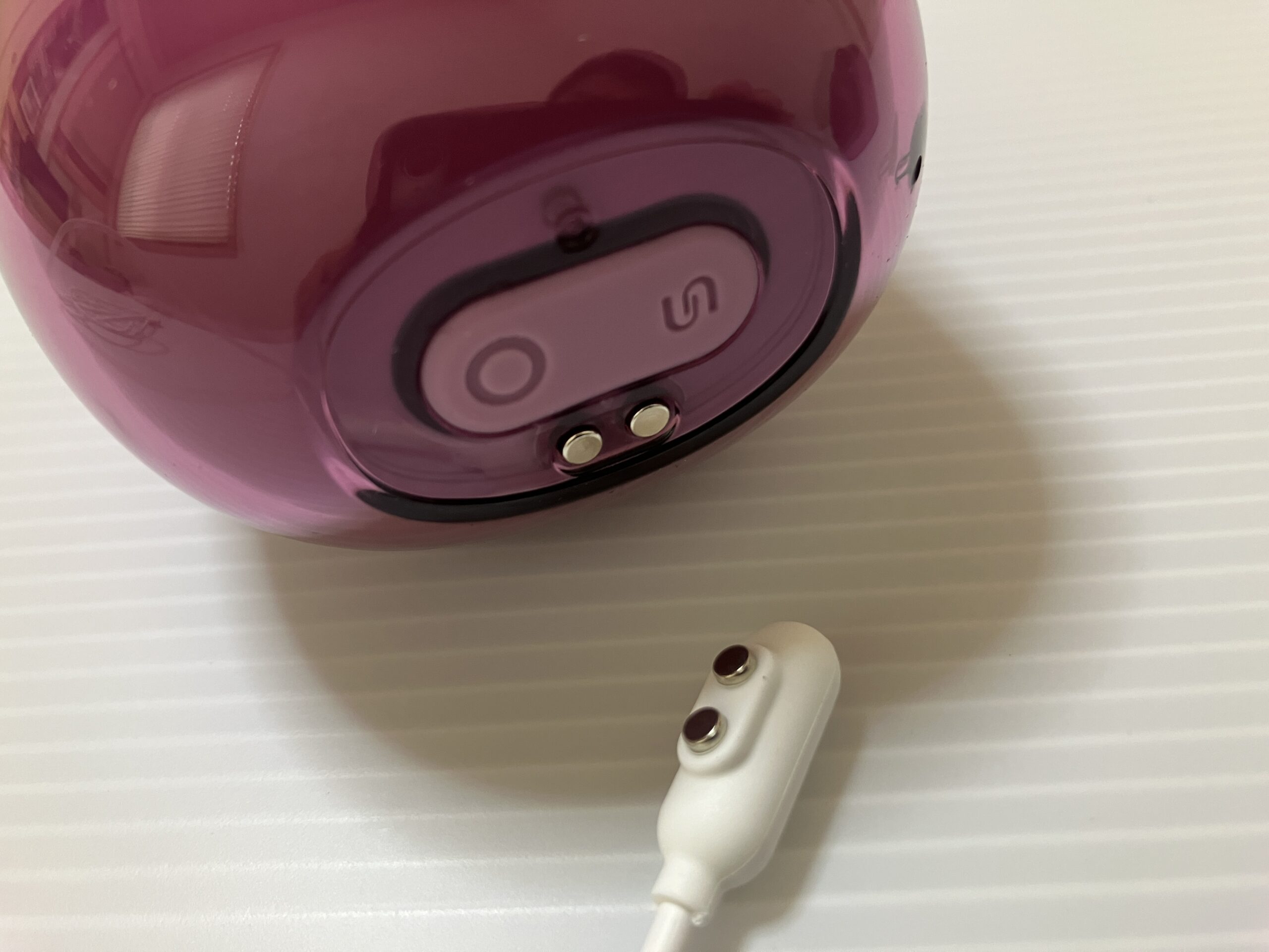 アダルトグッズブランドSVAKOMのklitty本体。下部には口と舌のスイッチと、吸引のスイッチ、マグネット式充電端子がある。
